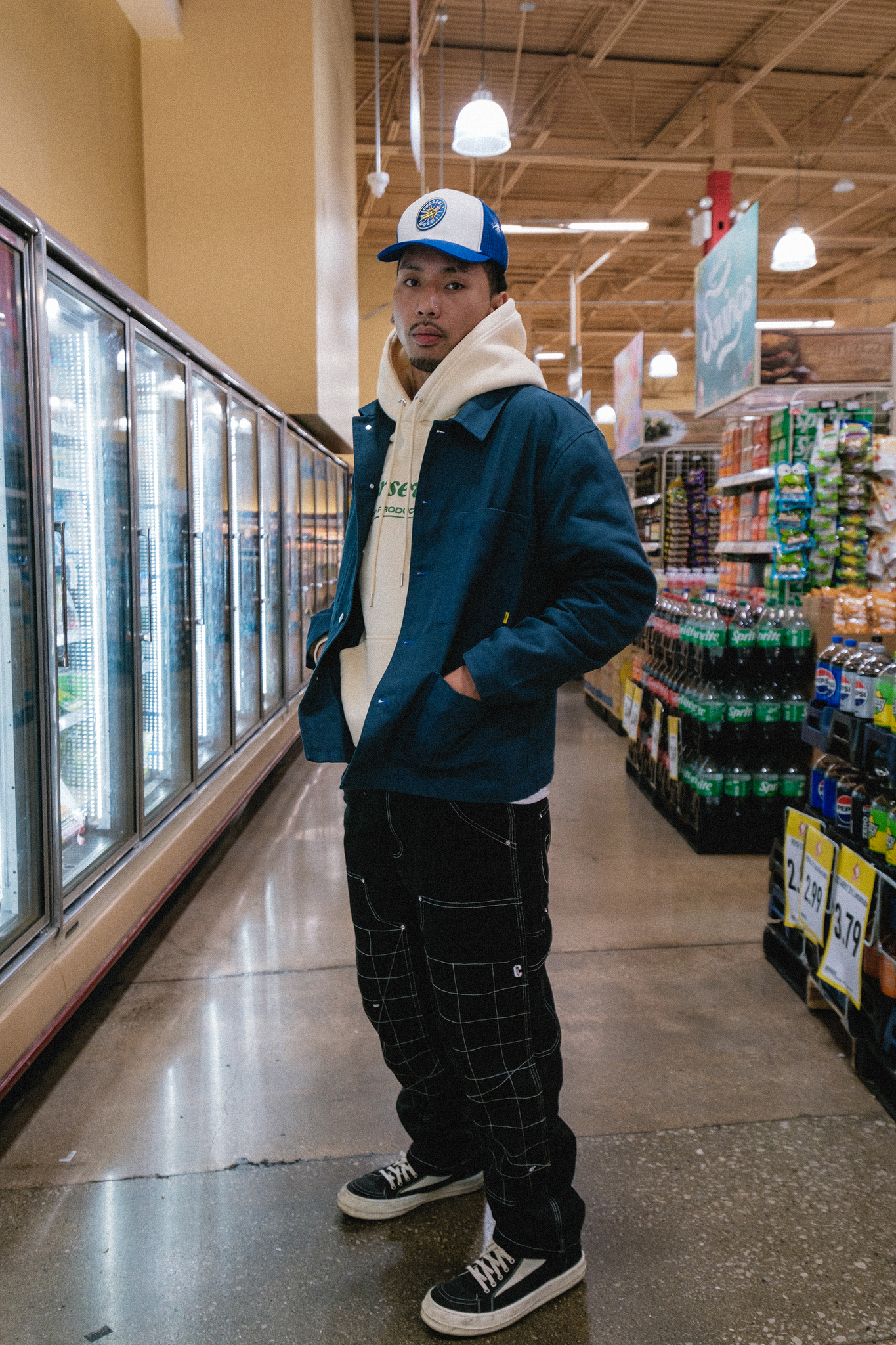 Model standing by refrigerated aisle of grocery store