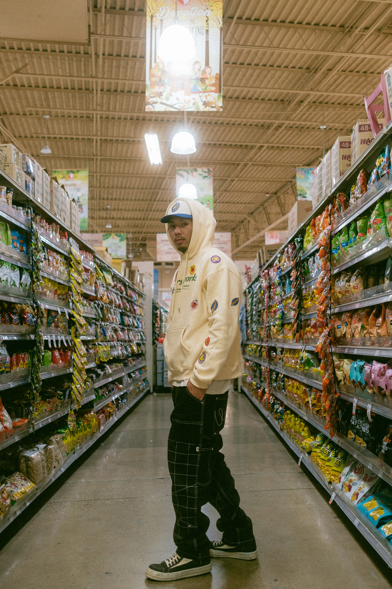 Model standing in center of empty aisle of Asian grocery store