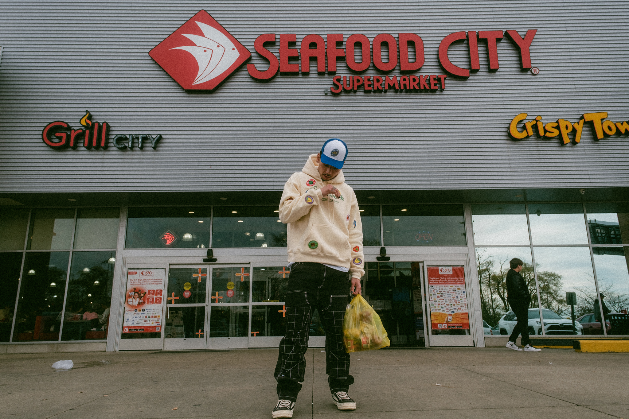 Model stands in front of grocery store entrance