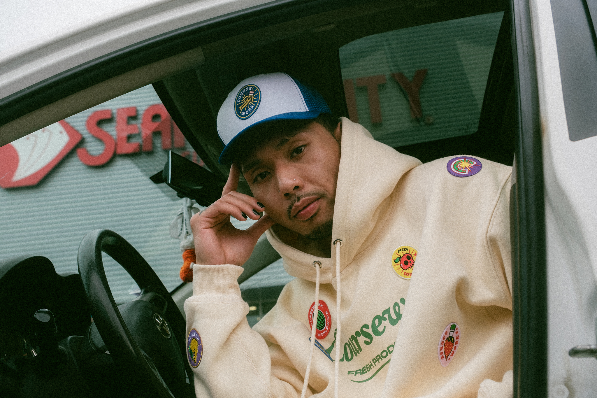 Model sits in car with door open